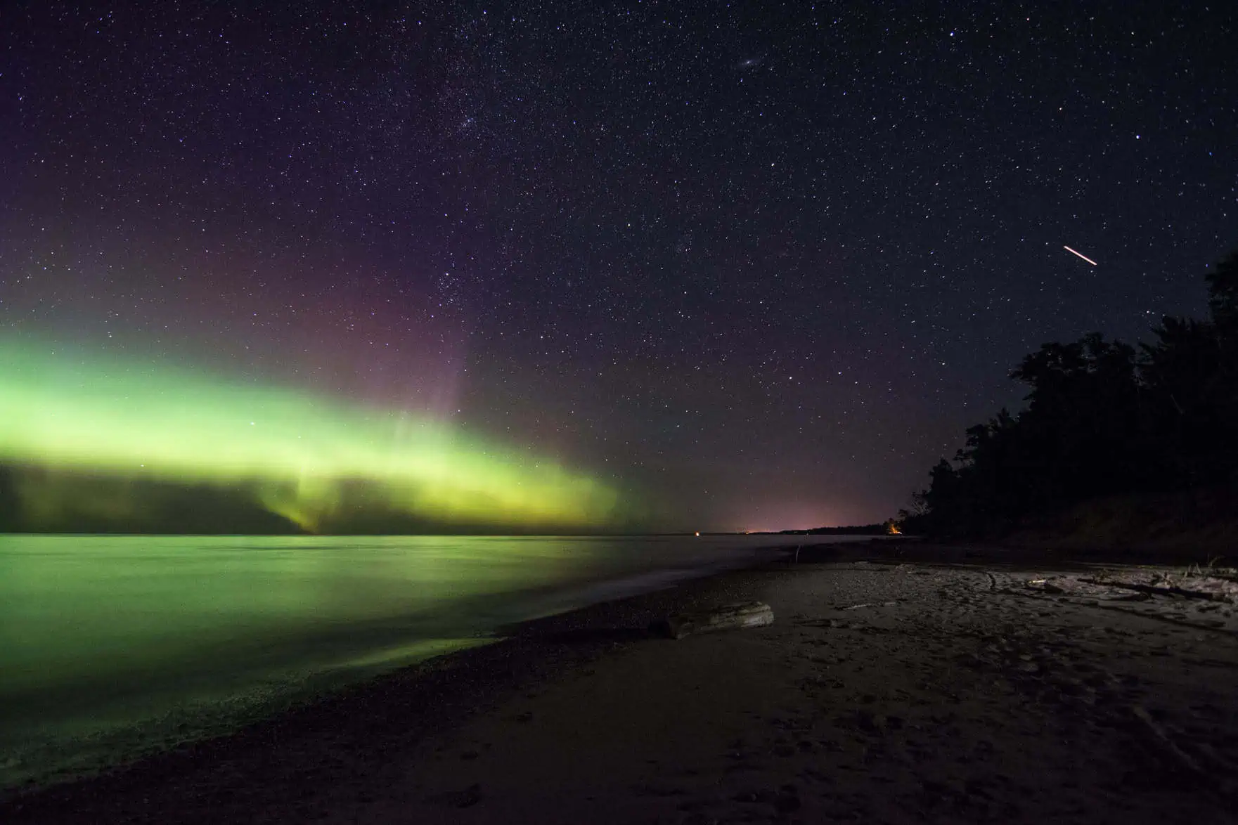 Bright northern lights over Ontonagon, Michigan, beneath a starry night sky.