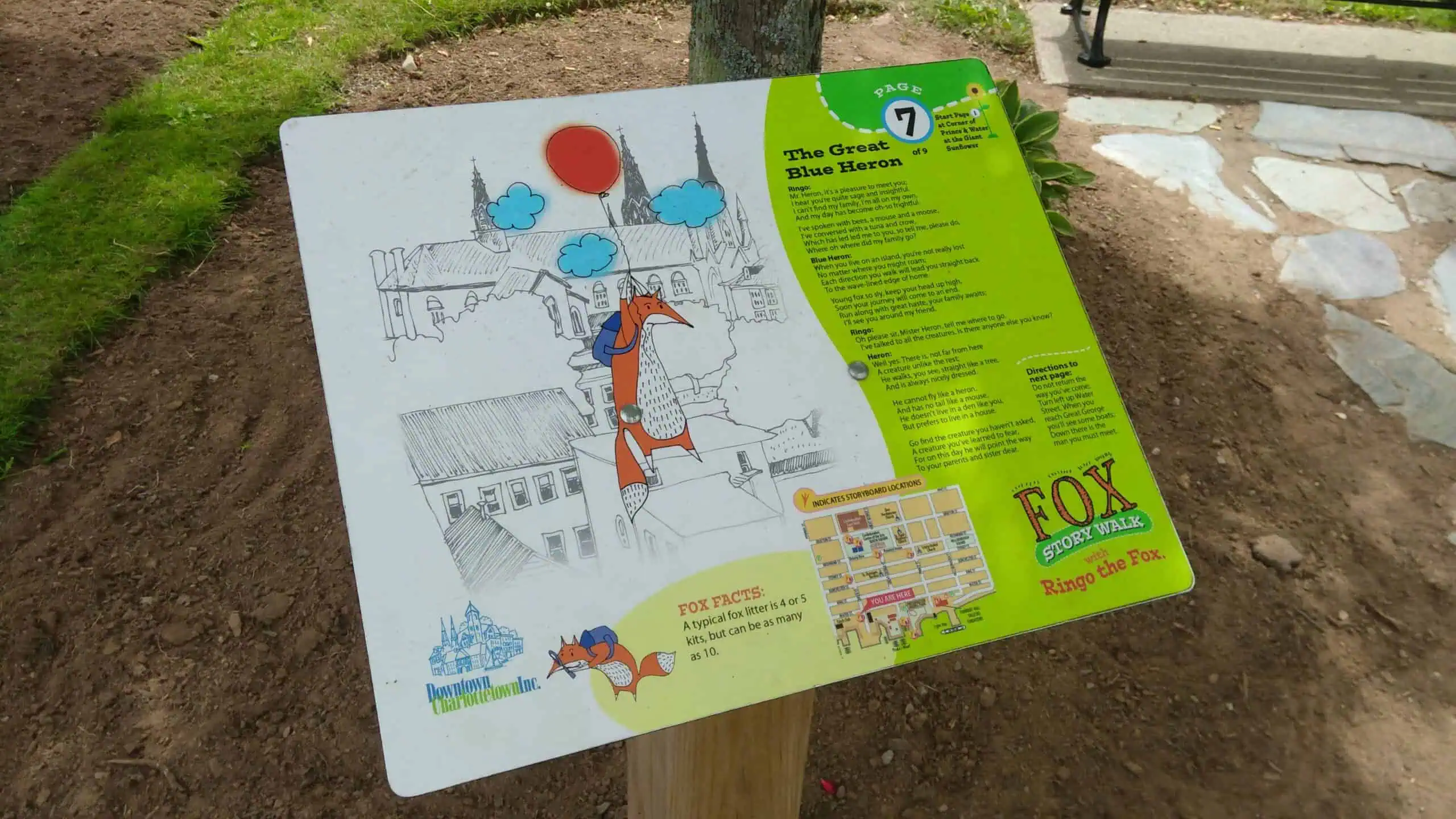 StoryWalk page display mounted beside a Great Blue Heron sculpture.