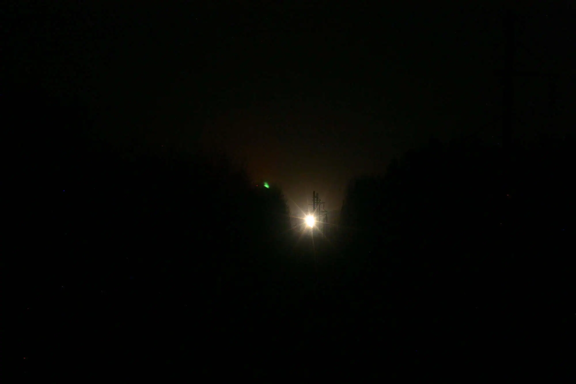 The Paulding Light, a distant glow above the tree line at night.