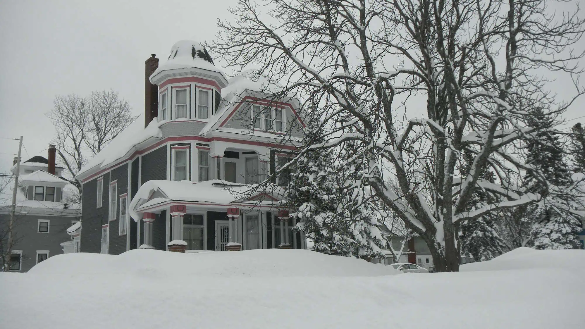 A house in Laurium, Michigan with snow banked to the eaves.